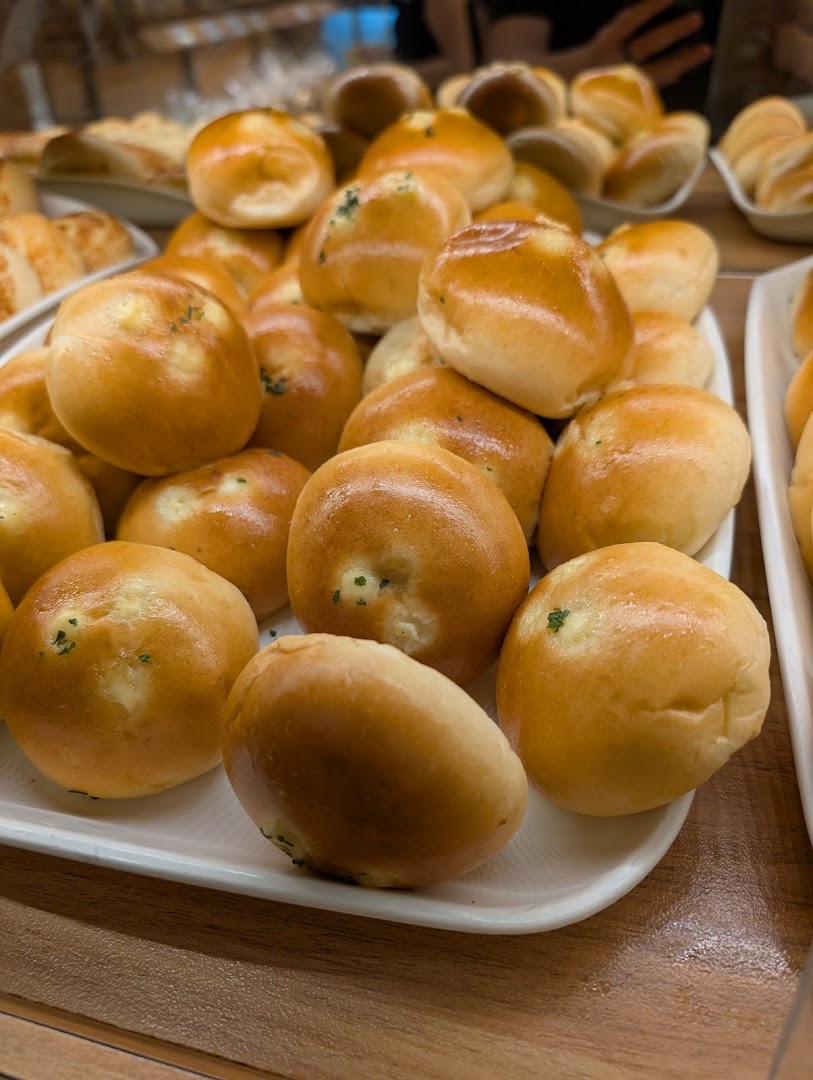 A display of freshly baked golden bread rolls, some with cheese and herb fillings, at Epi Dor.