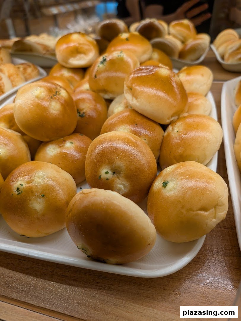 A display of freshly baked golden bread rolls, some with cheese and herb fillings, at Epi Dor.