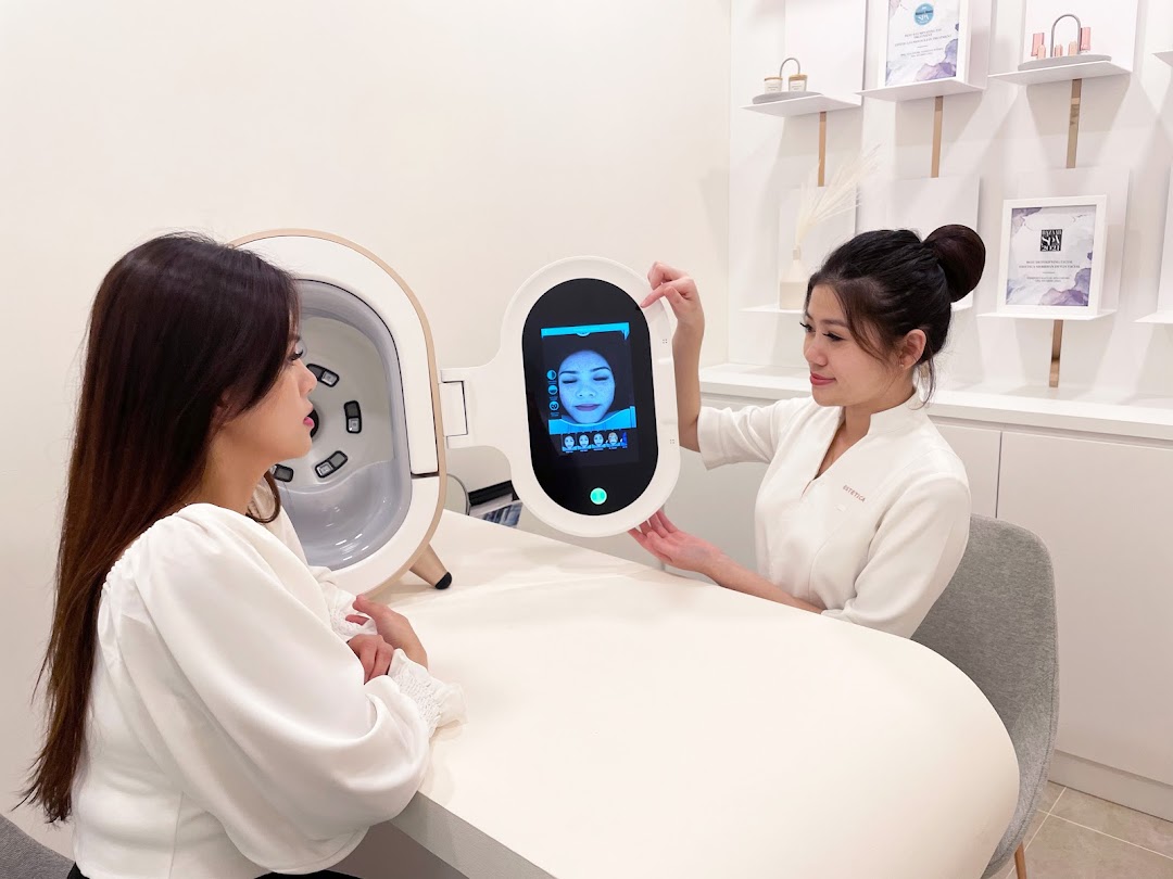 Two women, one staff and one client, engaging with an advanced skin analysis device in a modern beauty salon.