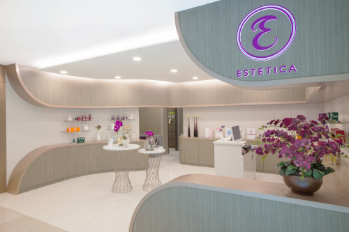 A clean and modern interior view of Estetica Beauty, featuring product displays and a reception area.