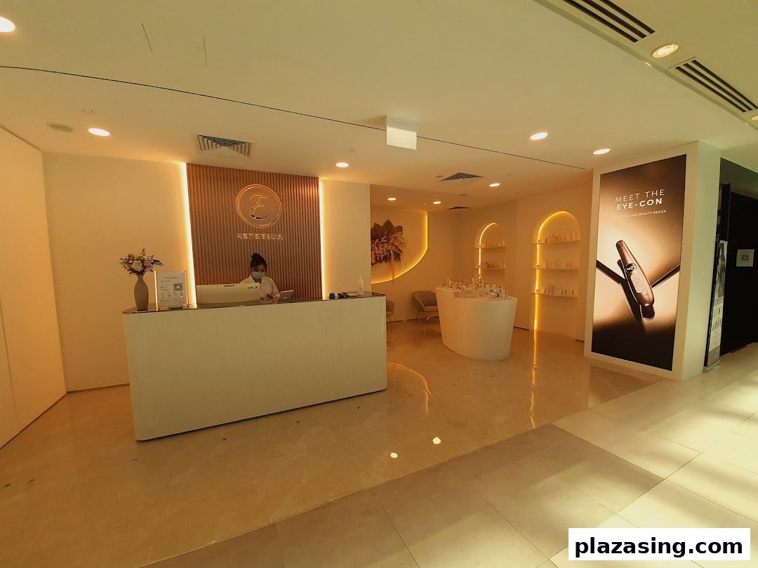 The reception area of Estetica Beauty, featuring a staff member, product displays, and a promotional poster.