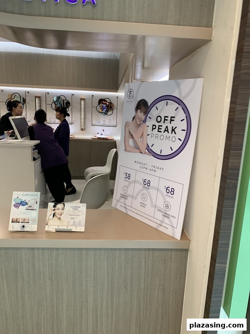 Interior view of Estetica Beauty, showcasing staff at the counter and prominent promotional signs for beauty treatments.