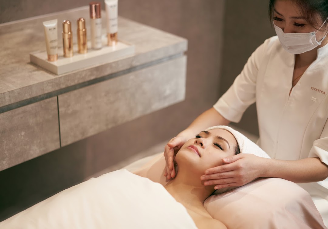 A therapist performs a relaxing facial treatment on a client at Estetica Beauty.