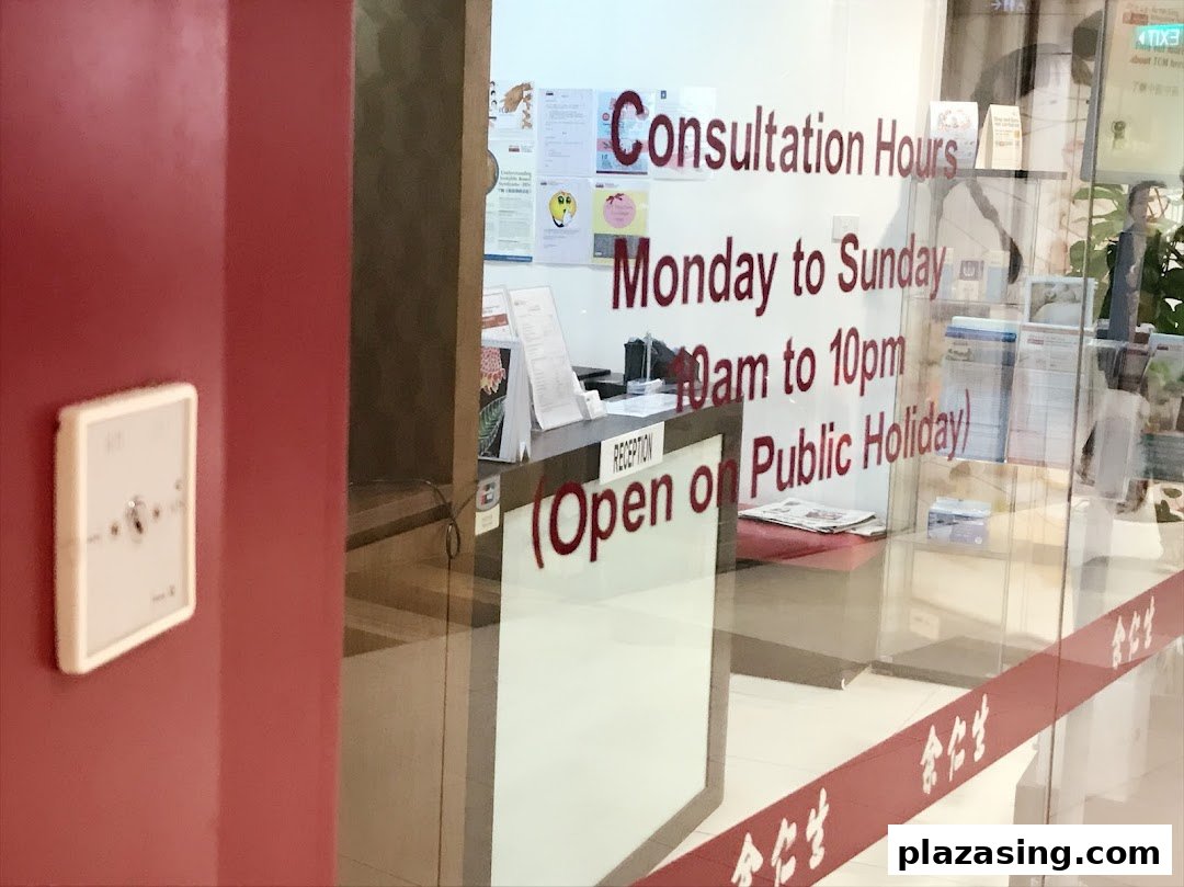 The entrance of Eu Yan Sang TCM Clinic, displaying consultation hours on the glass door.