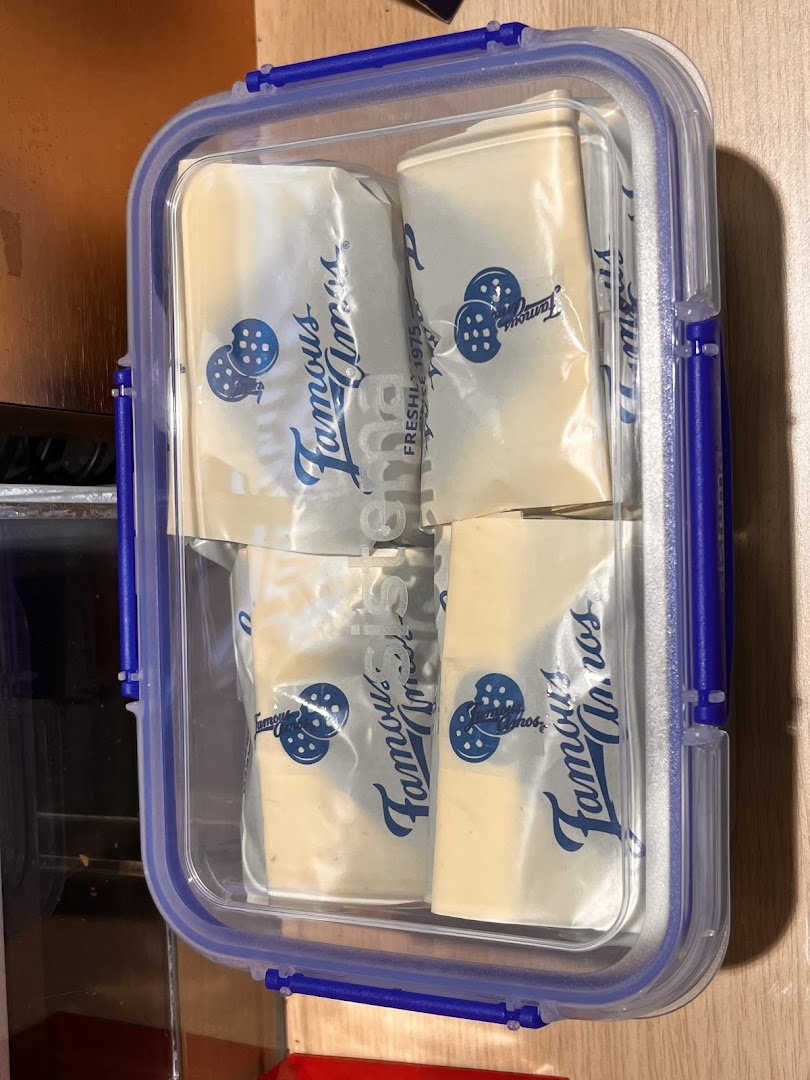 Famous Amos cookies in individual packets stored in a clear plastic container.