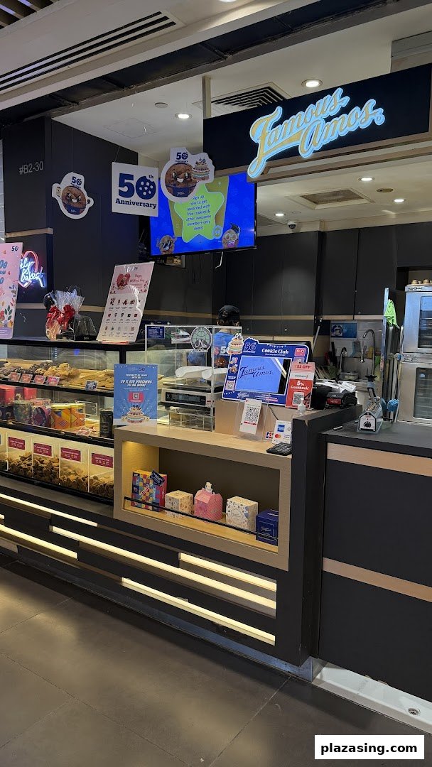 Interior view of Famous Amos cookie shop, showcasing the counter, cookie displays, and branding.