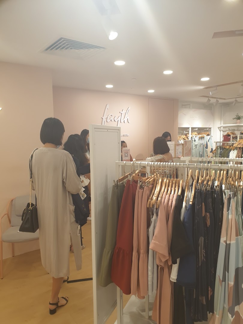 Interior view of Fayth Plaza Singapura, showcasing clothing racks and customers browsing apparel.