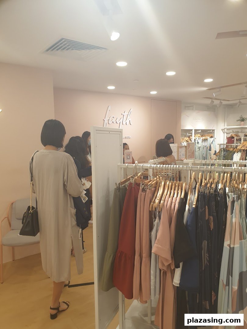 Interior view of Fayth Plaza Singapura, showcasing clothing racks and customers browsing apparel.