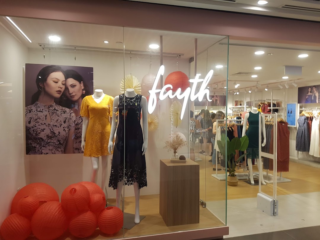 The bright storefront of Fayth fashion boutique showcasing dresses on mannequins and a view into the stylish interior.