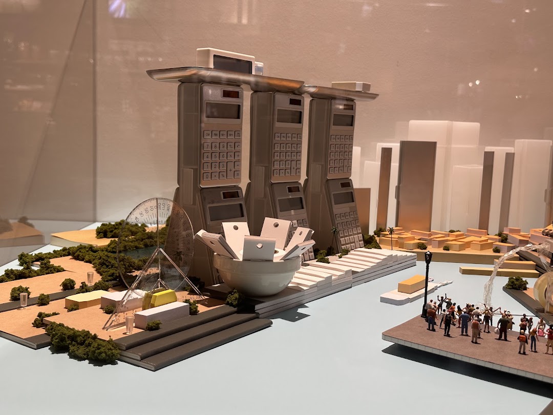 A creative miniature city model featuring iconic Singaporean landmarks reimagined with office supplies like calculators.