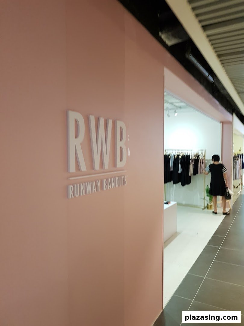 The shop front of Runway Bandits, featuring a pink wall with white 3D lettering and an open entrance.