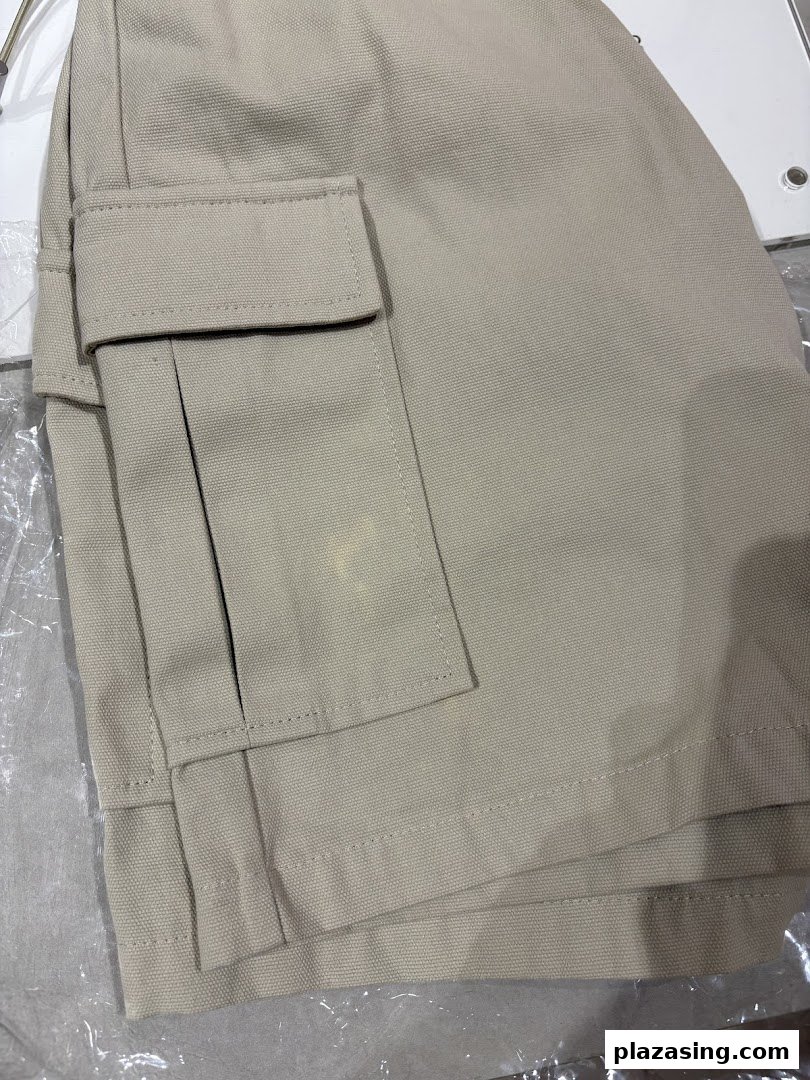 Close-up of beige cargo shorts or pants, showcasing fabric texture and pocket detail.