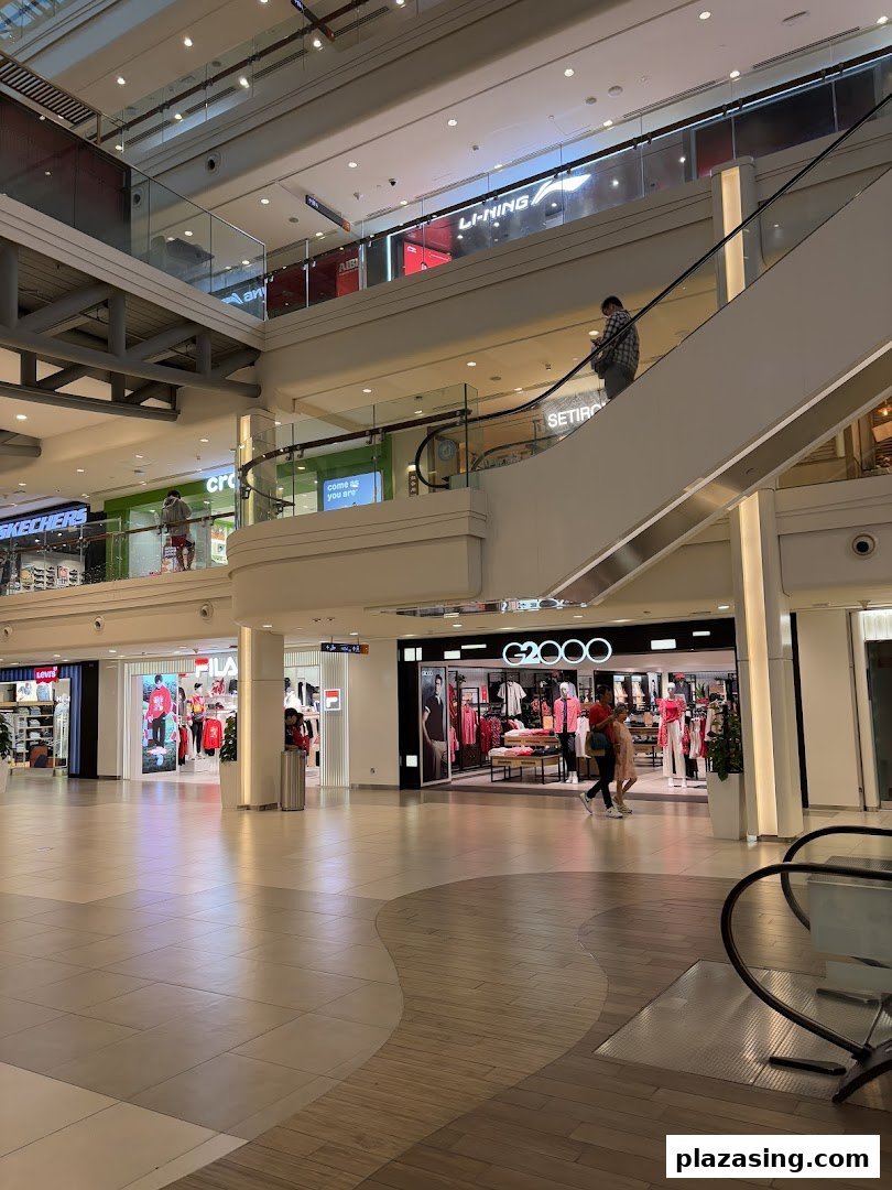 The G2000 shop entrance in a bustling multi-level shopping mall, showcasing modern apparel on mannequins.