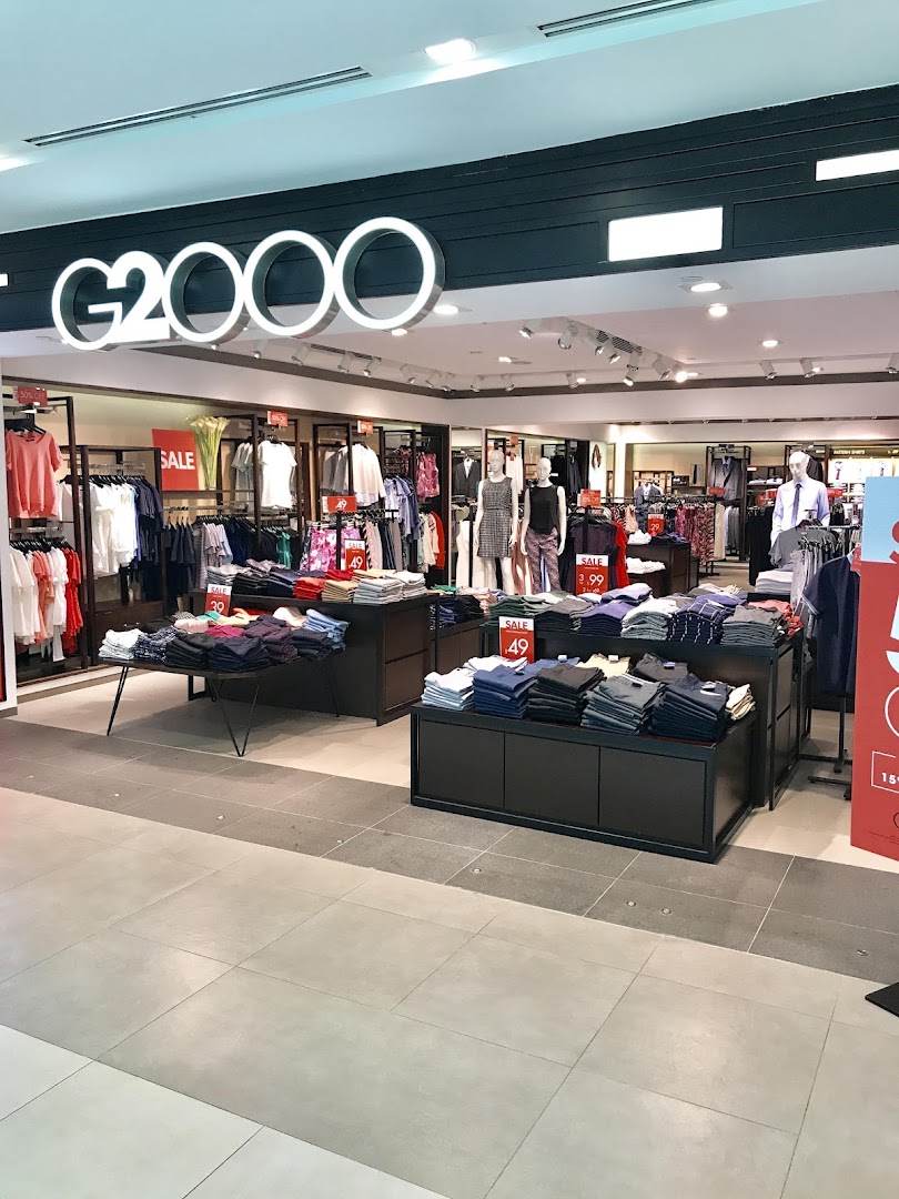 An interior view of the G2000 clothing store, showcasing various apparel displays and sale items.