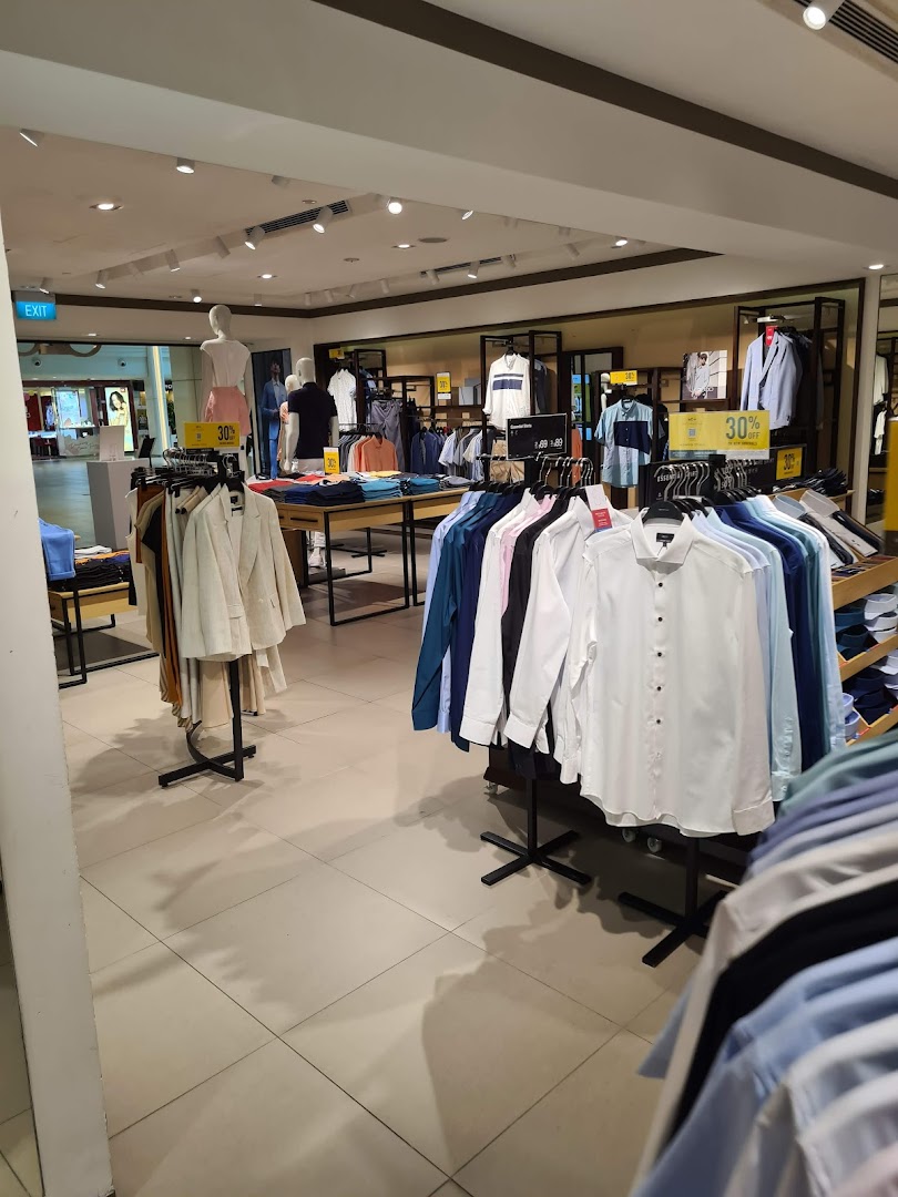 An interior view of G2000, showcasing racks of men's and women's apparel, mannequins, and sale signs.