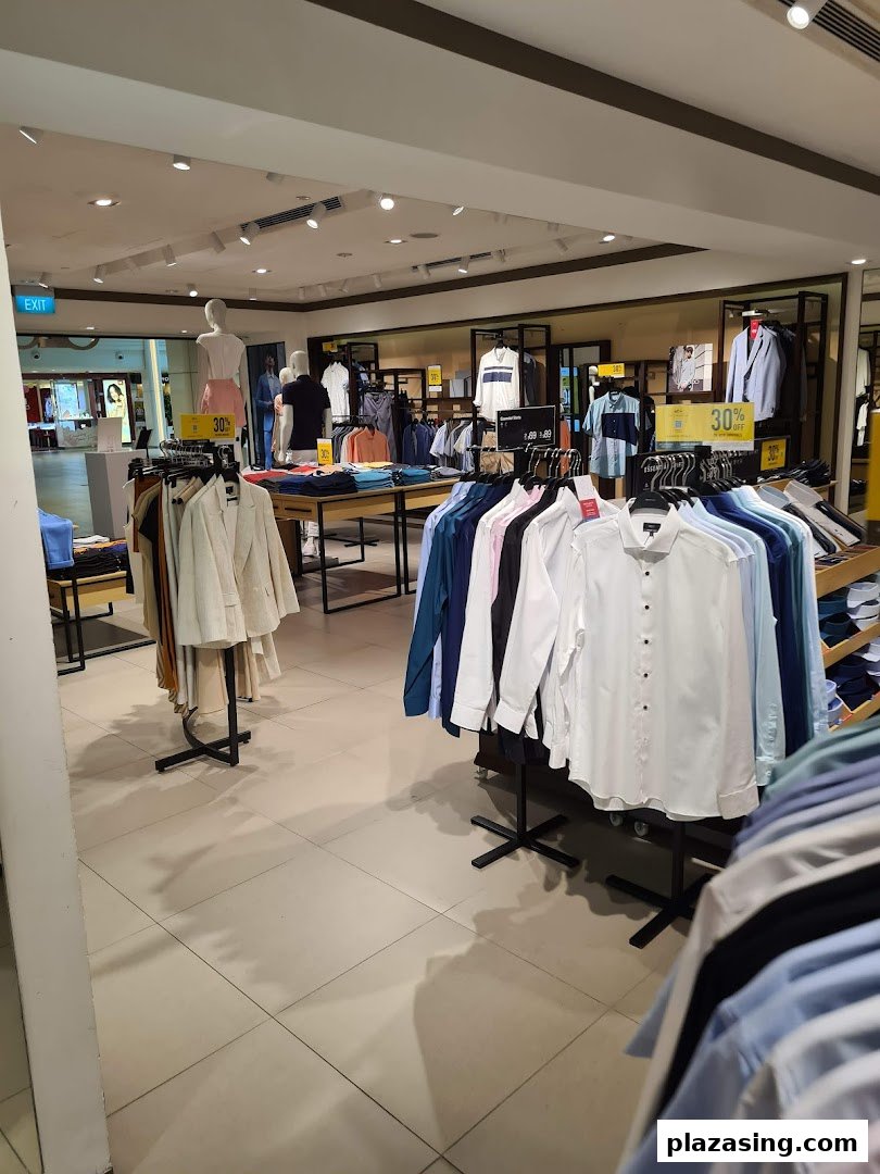 An interior view of G2000, showcasing racks of men's and women's apparel, mannequins, and sale signs.