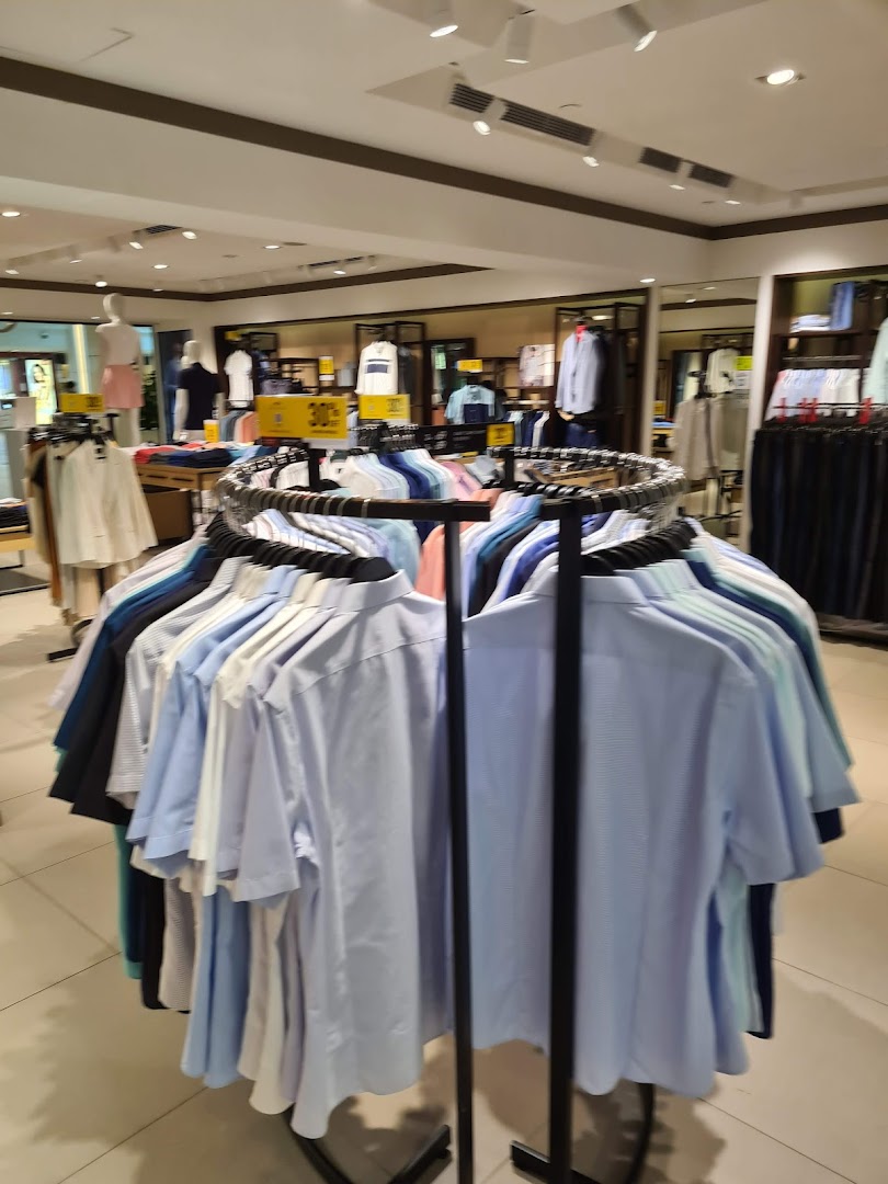 An interior view of G2000 showcasing a circular display rack filled with men's shirts and other apparel.