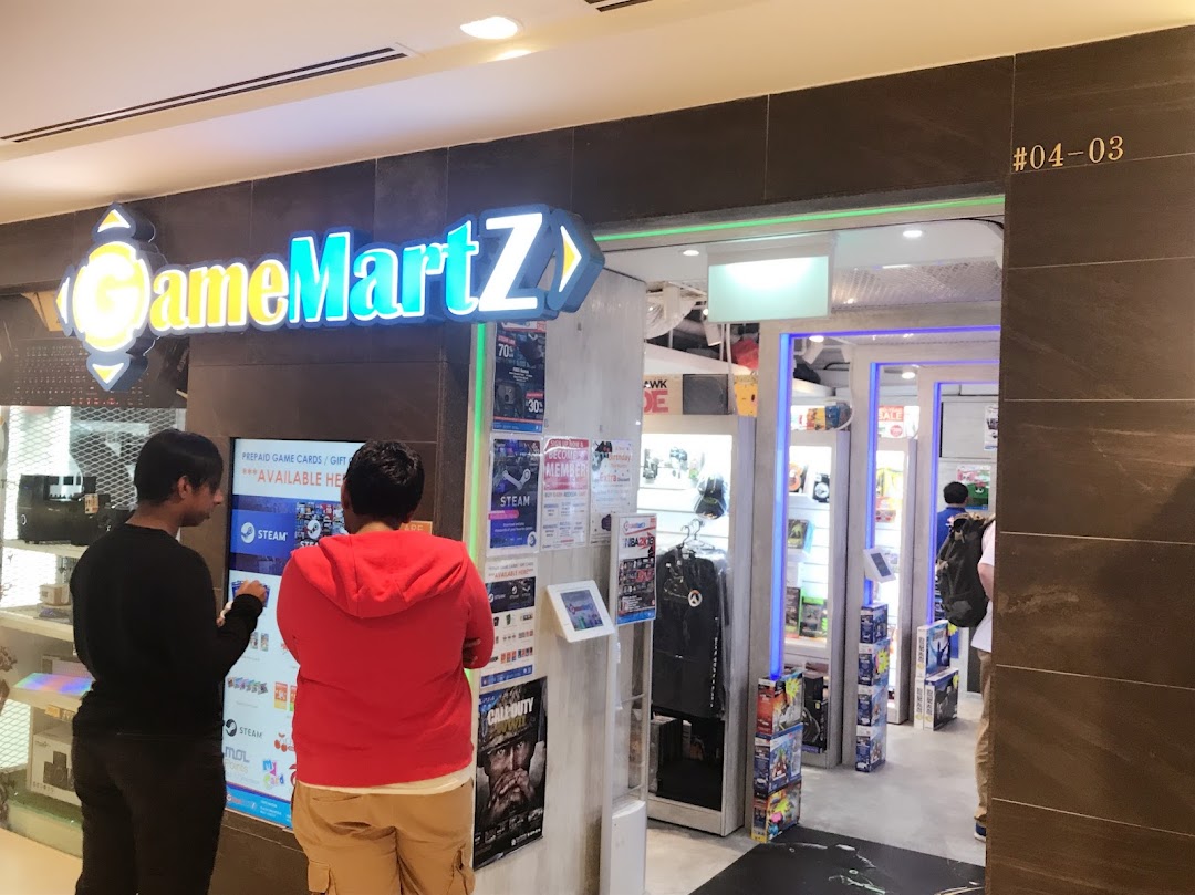 The brightly lit entrance of GameMartz, a gaming store, with customers browsing displays.