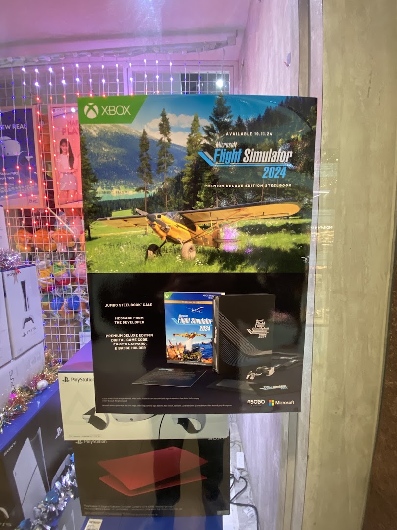 A large poster for Microsoft Flight Simulator 2024 Premium Deluxe Edition Steelbook inside a gaming shop.