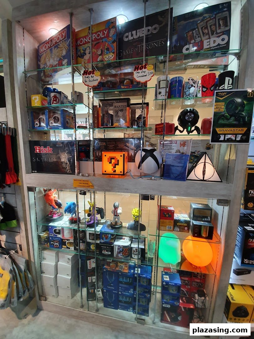 A glass display cabinet showcasing board games, video game merchandise, and pop culture collectibles.