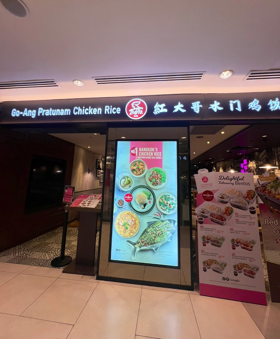 The storefront of Go-Ang Pratunam Chicken Rice, featuring promotional displays for their signature dishes and takeaway bentos.