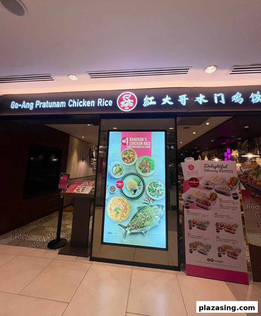 The storefront of Go-Ang Pratunam Chicken Rice, featuring promotional displays for their signature dishes and takeaway bentos.