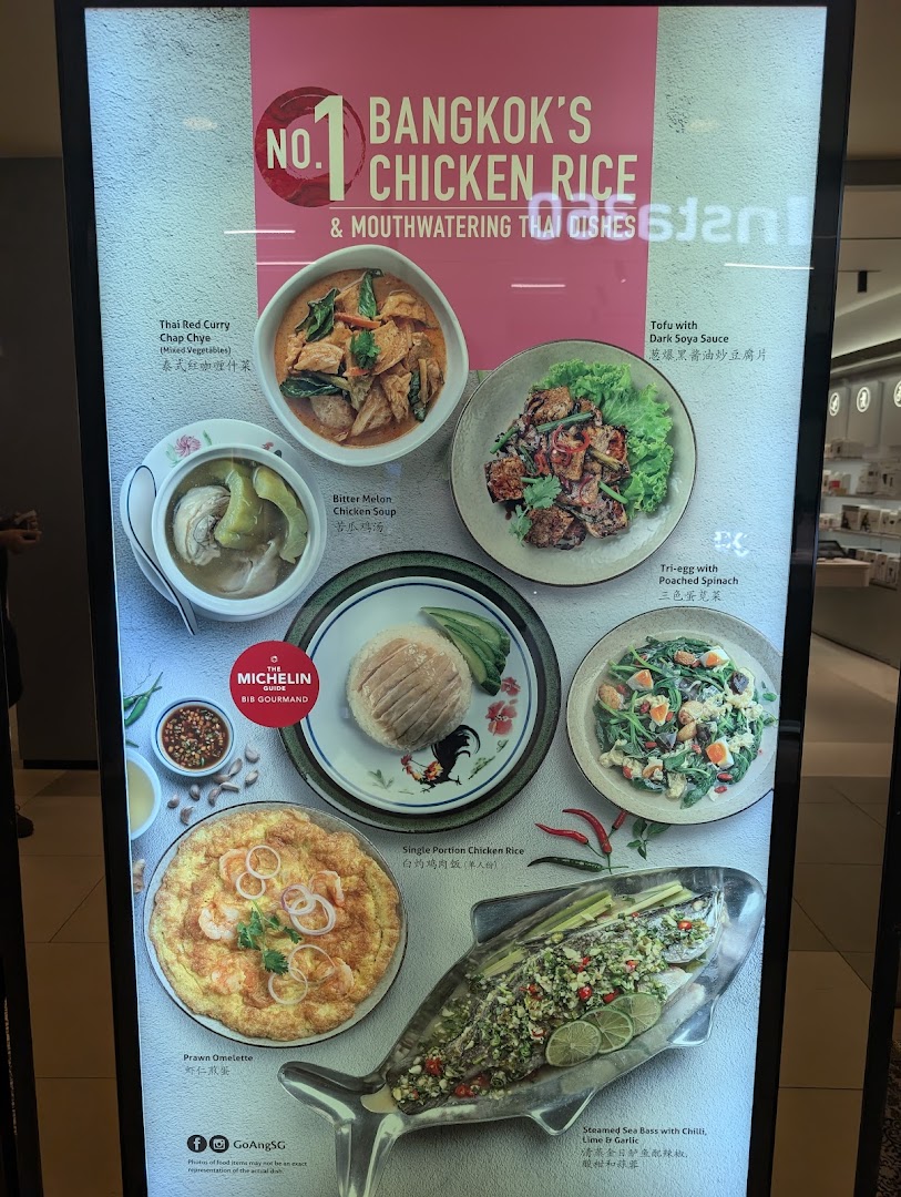 A vibrant display board showcasing various Thai dishes, including chicken rice and seafood, from Go-Ang Pratunam Chicken Rice.
