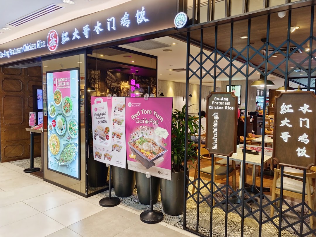 The storefront of Go-Ang Pratunam Chicken Rice, featuring promotional posters and a welcoming entrance.