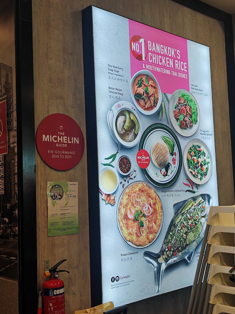 An illuminated display board showcasing Go-Ang Pratunam Chicken Rice's signature dishes and Michelin Bib Gourmand recognition.