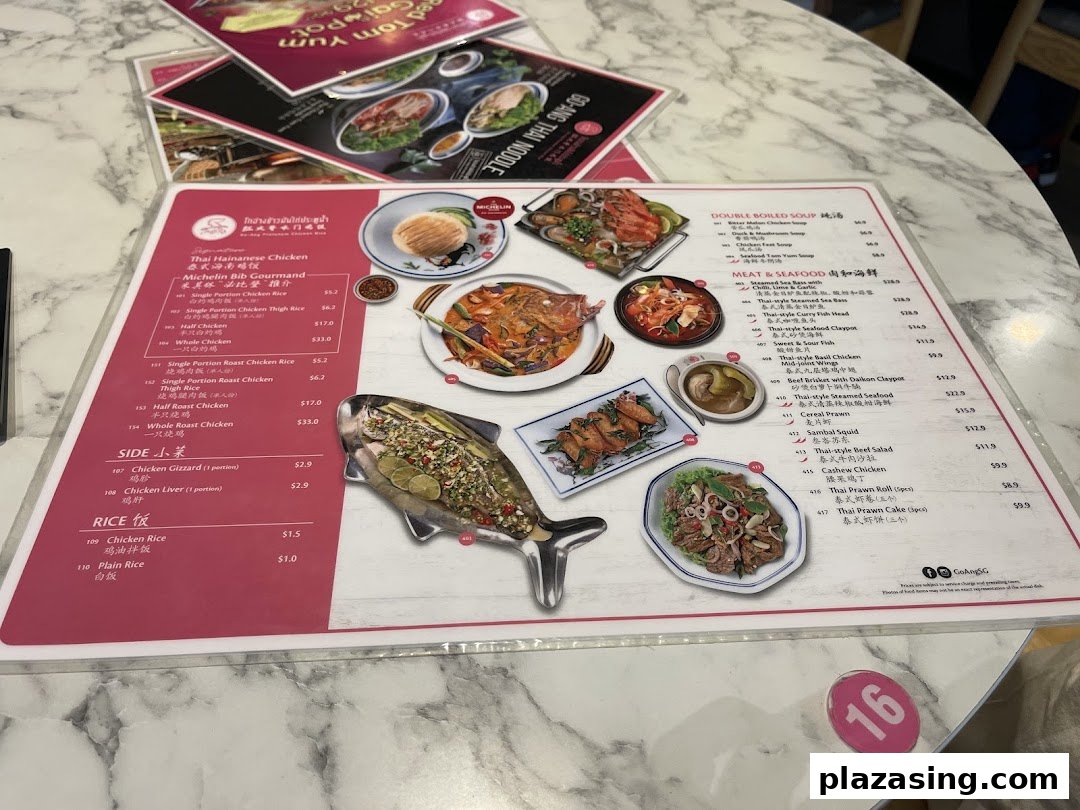 A detailed close-up of Go-Ang Pratunam Chicken Rice's menu, showcasing various Thai dishes.