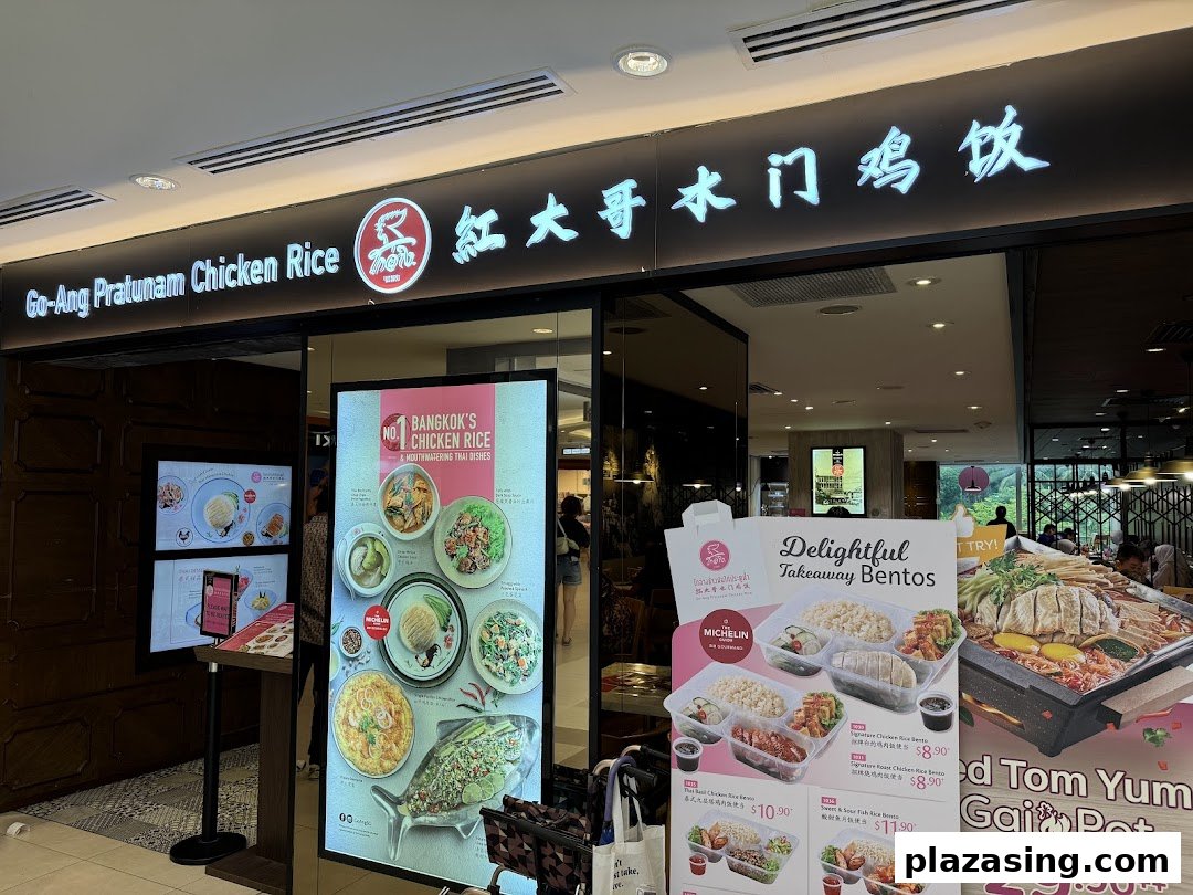 The storefront of Go-Ang Pratunam Chicken Rice, featuring its signage and promotional displays for takeaway bentos.
