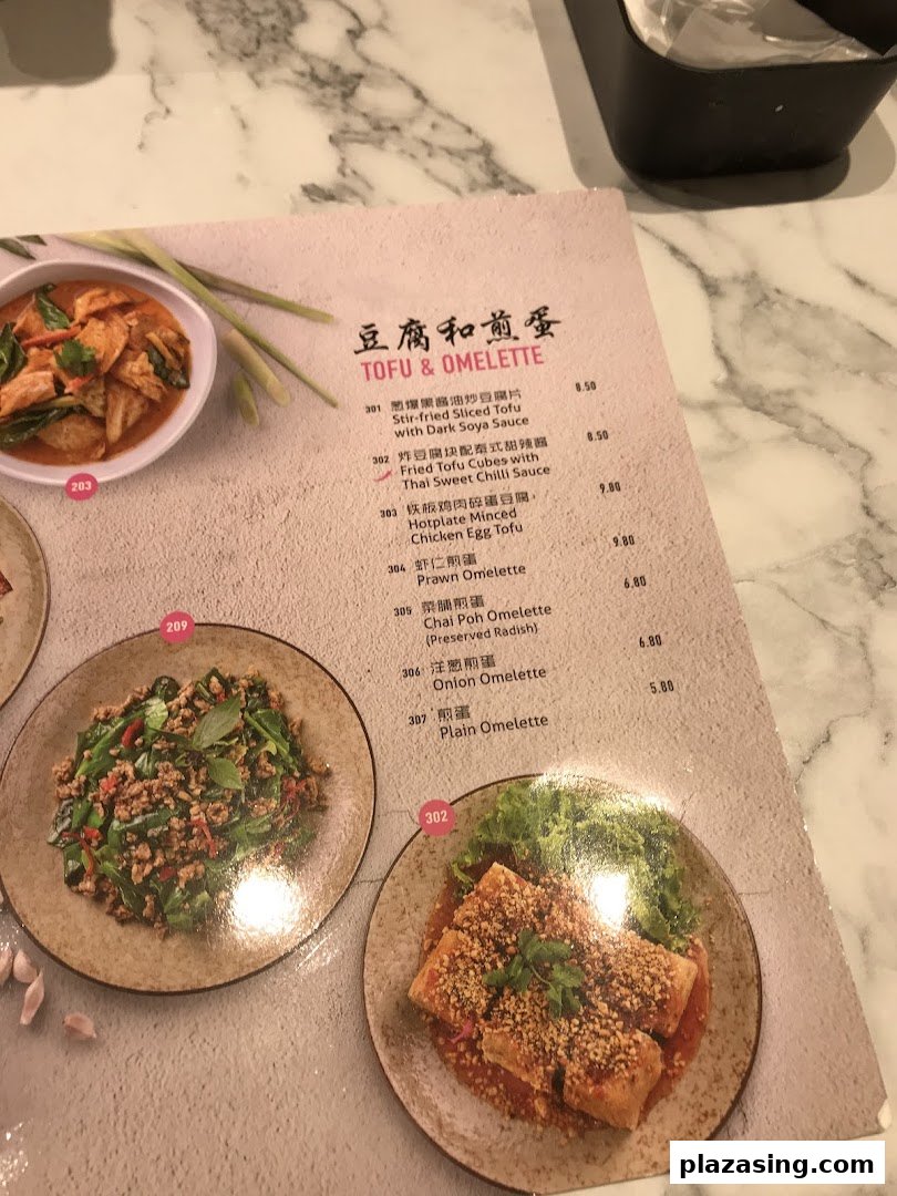 A menu page from Go-Ang Pratunam Chicken Rice, showcasing a variety of tofu and omelette dishes with prices.