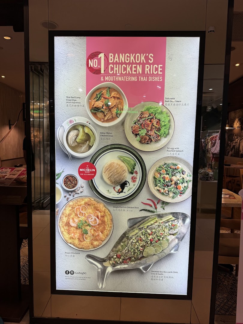 A brightly lit display board showcasing various Thai dishes, including chicken rice, curries, and seafood.