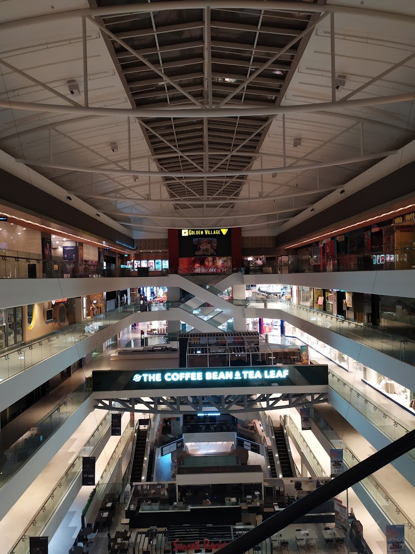 An expansive view of a multi-level shopping mall interior with escalators and various retail outlets.