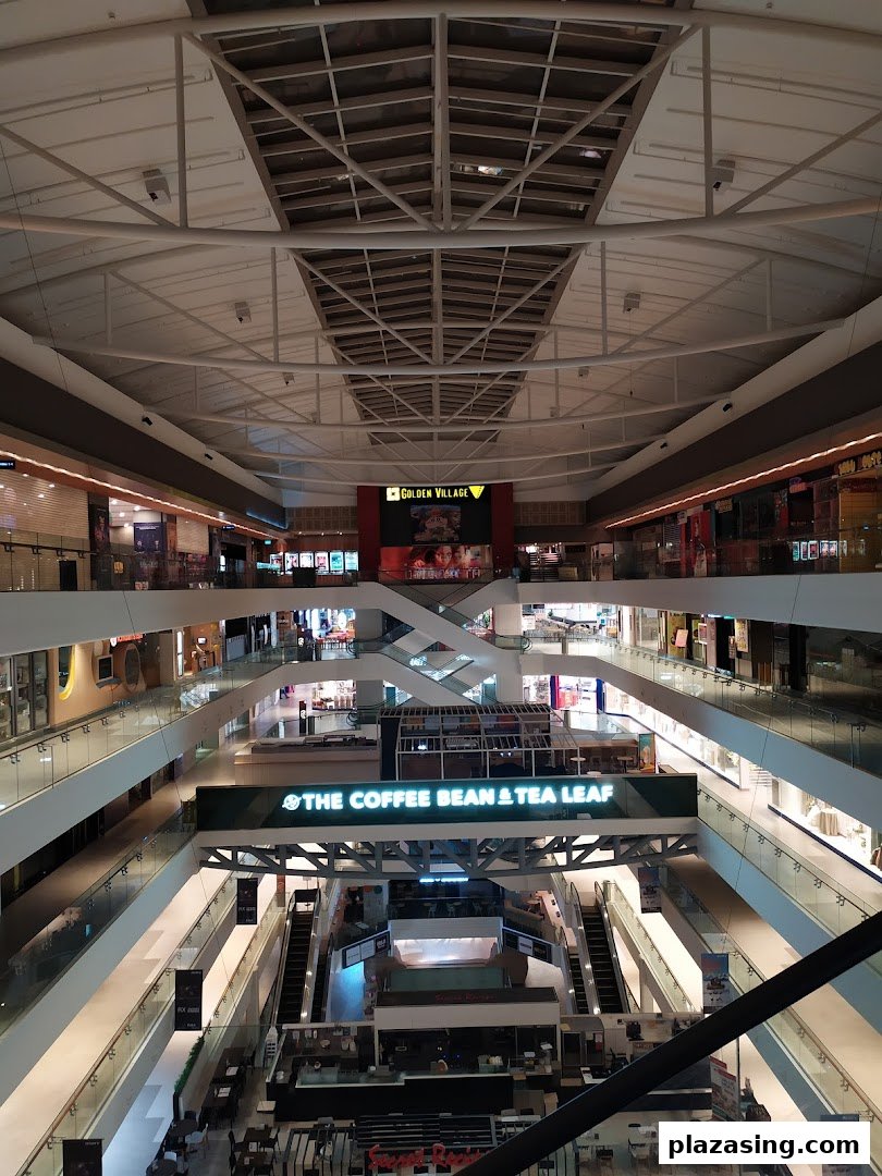 An expansive view of a multi-level shopping mall interior with escalators and various retail outlets.
