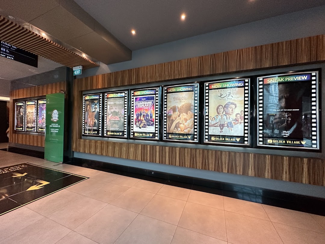 Illuminated movie posters showcasing current and upcoming films at Golden Village cinema.