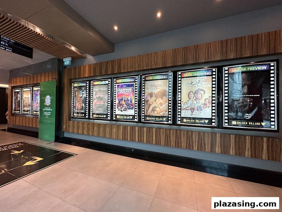 Illuminated movie posters showcasing current and upcoming films at Golden Village cinema.