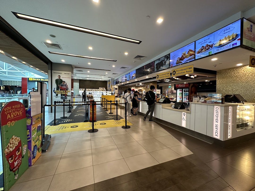 A bustling cinema lobby with a concession stand, digital menu boards, and a queue area.
