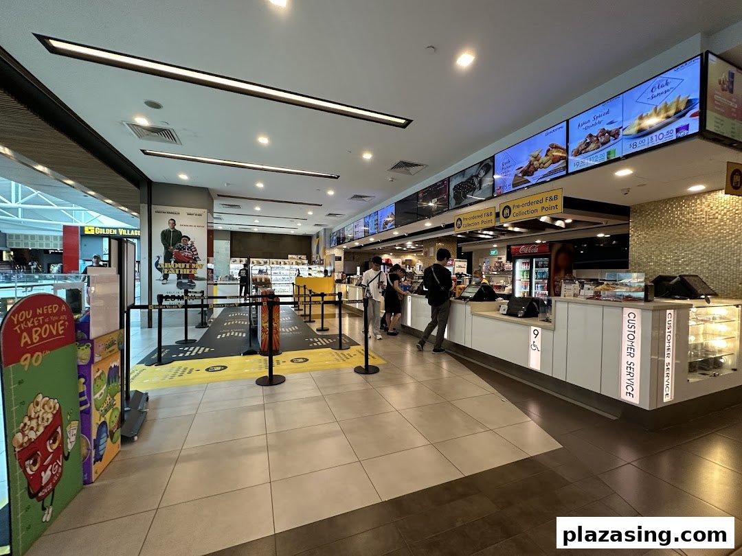 A bustling cinema lobby with a concession stand, digital menu boards, and a queue area.