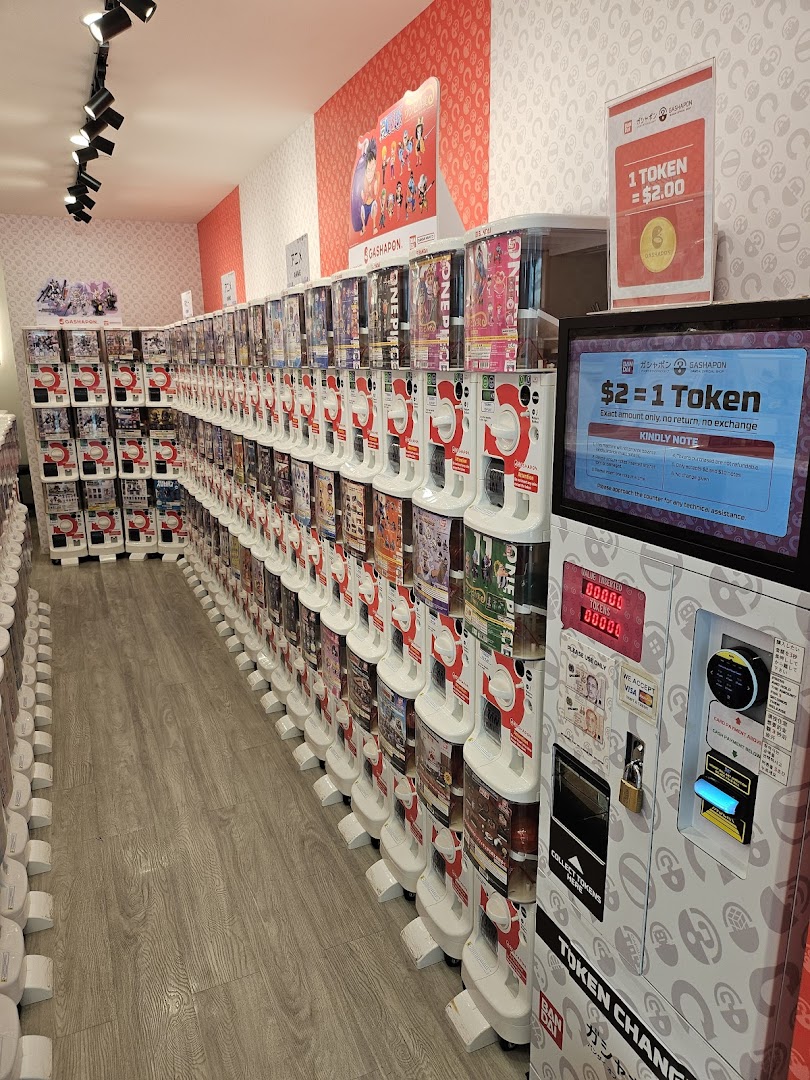 An interior view of a gashapon shop featuring rows of capsule toy vending machines.
