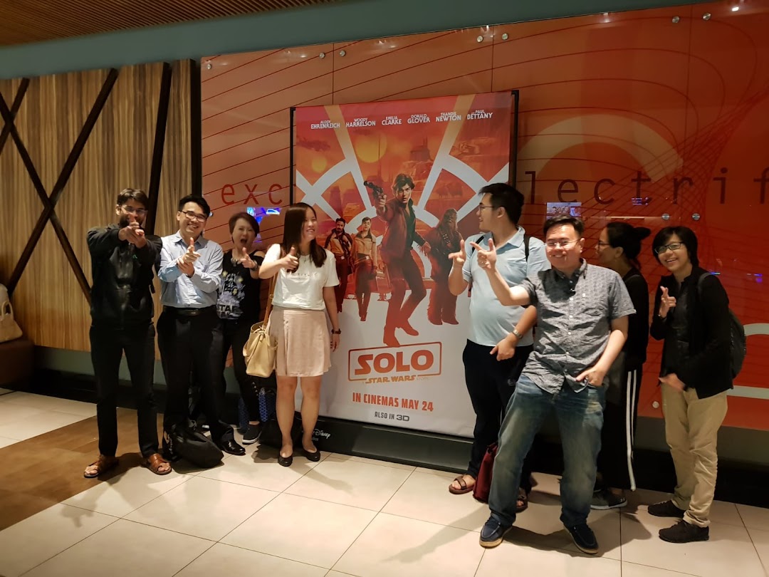 A group of friends posing happily in a cinema lobby next to a "Solo: A Star Wars Story" movie poster.