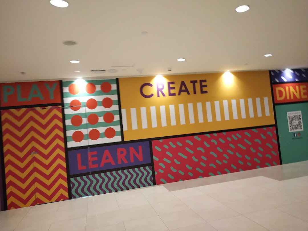 A vibrant, colorful wall featuring words 'PLAY', 'CREATE', 'LEARN', and 'DINE' at Golden Village Plaza.