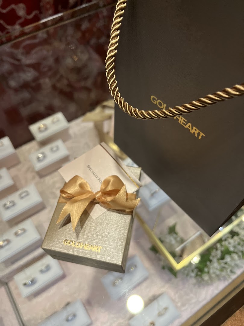 A close-up of Goldheart jewelry display with a branded gift box and shopping bag.