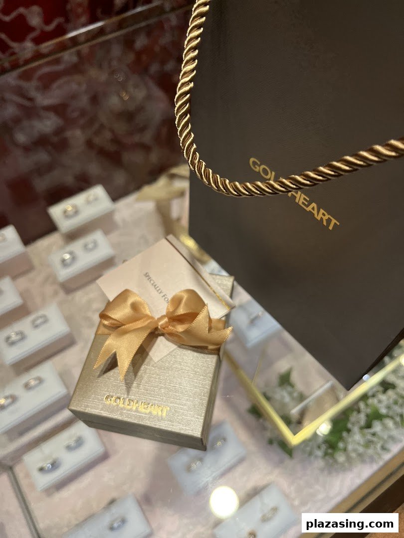 A close-up of Goldheart jewelry display with a branded gift box and shopping bag.
