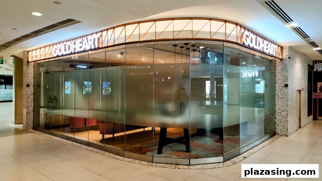 The exterior of Goldheart Jewelry at Plaza Singapura, featuring a modern glass facade and illuminated signage.