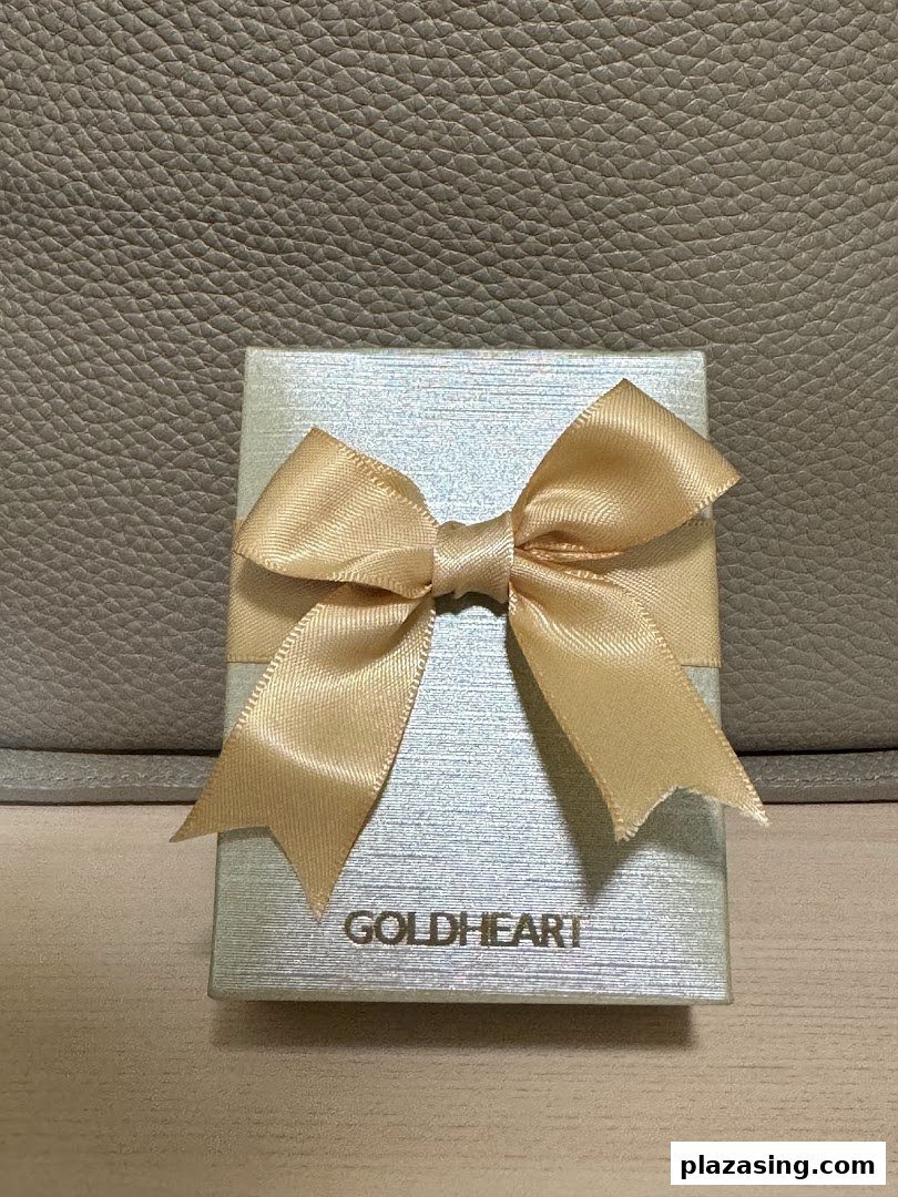 A light blue Goldheart gift box with a golden ribbon, ready for a special occasion.