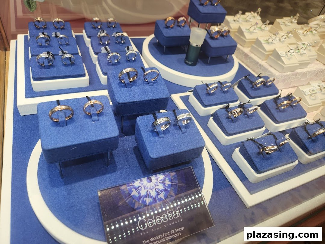 A display of various gold and diamond rings on blue velvet stands inside Goldheart Jewelry.