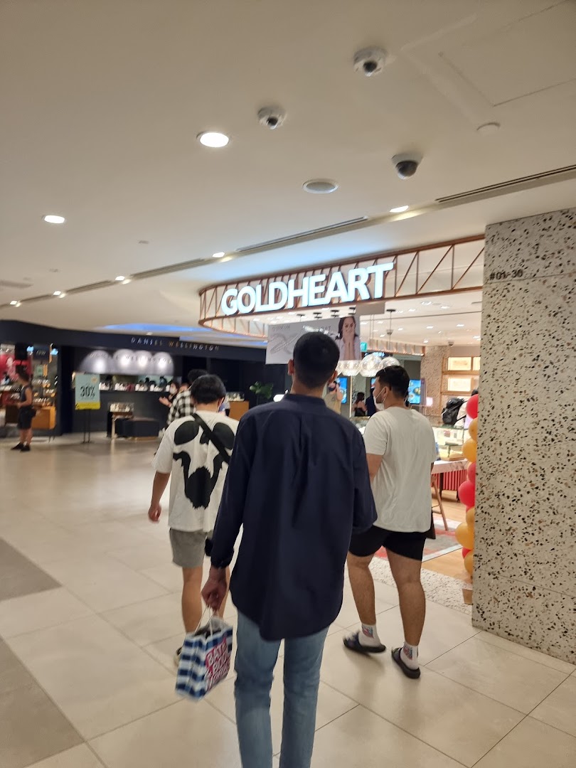 View of the Goldheart Jewelry shop entrance with shoppers passing by in a mall.