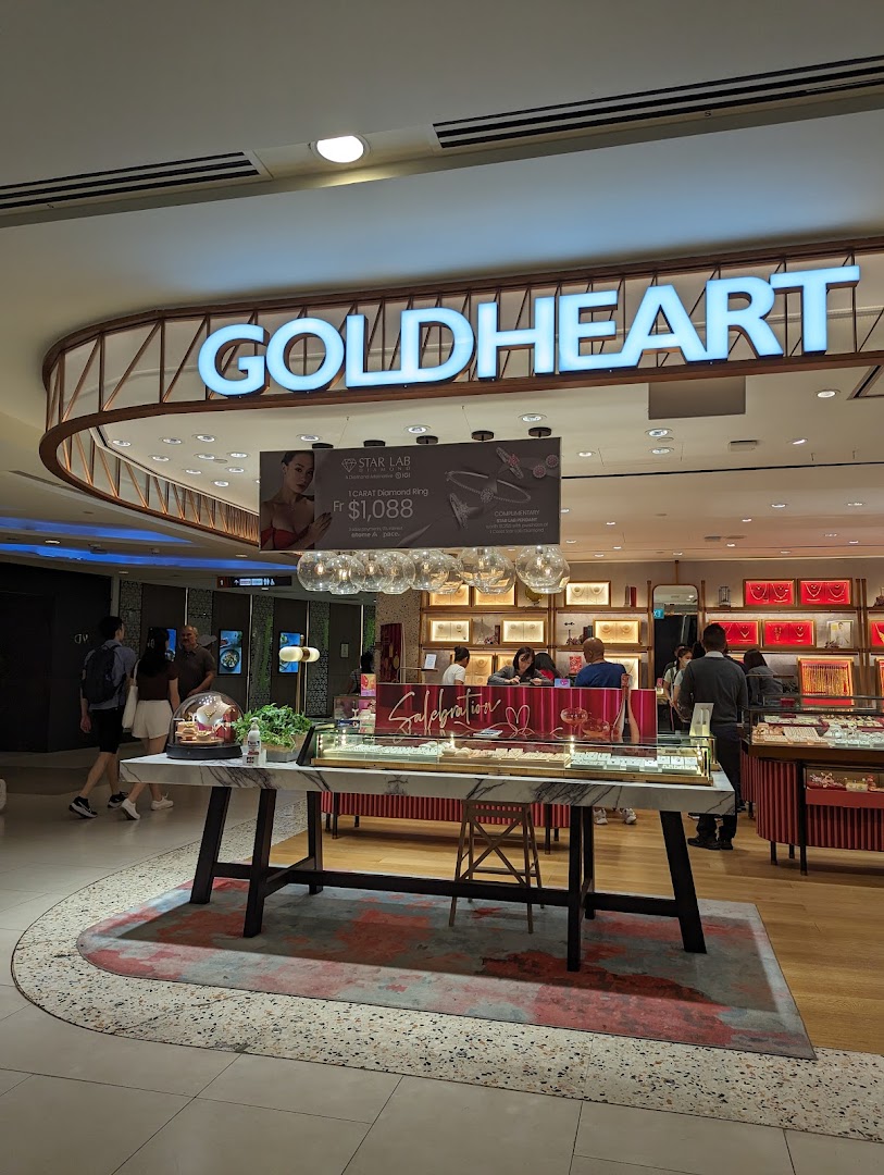 The illuminated Goldheart Jewelry shop front with display cases and customers inside.