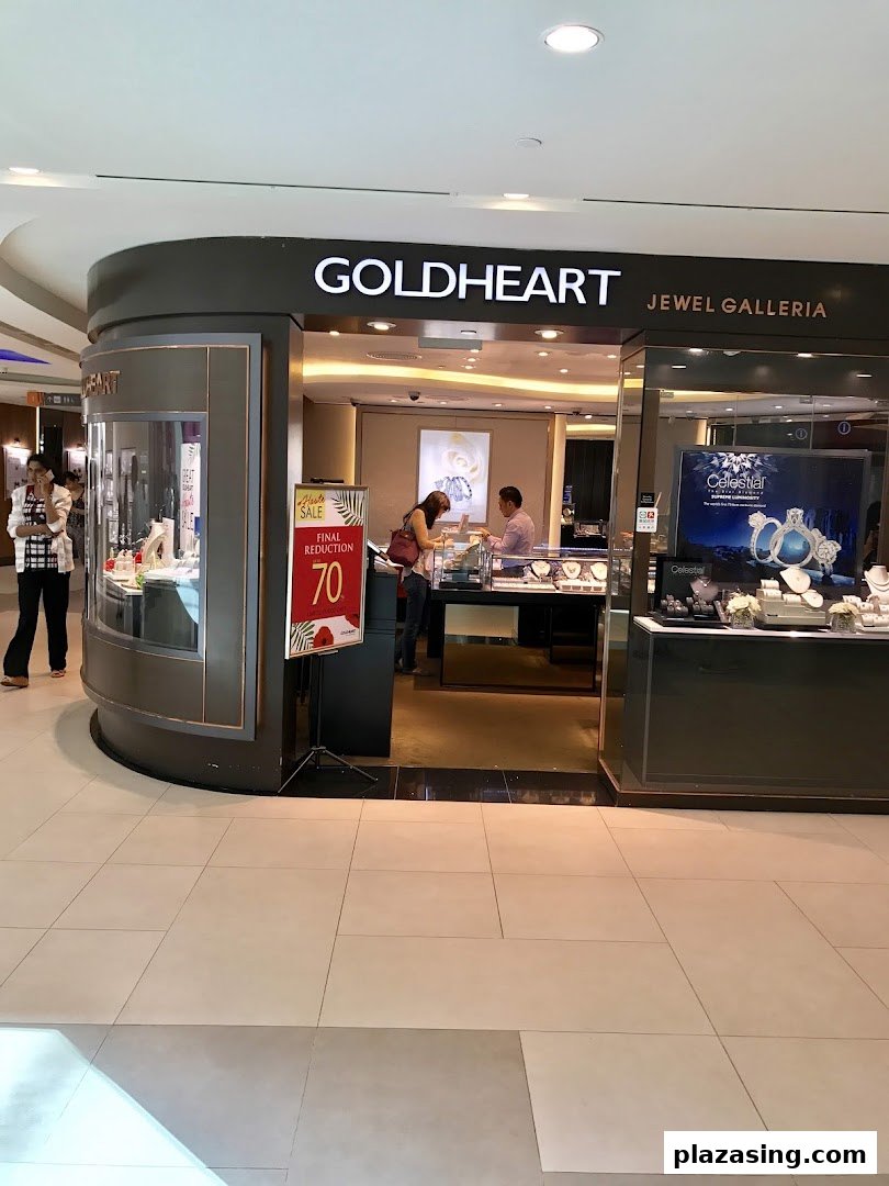The shop front of Goldheart Jewelry, featuring display cases, a sale sign, and customers browsing.